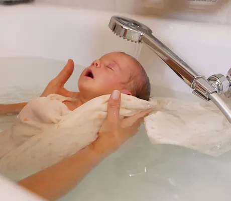 Un bébé se détend complétement pendant son thérapeutique bain bébé